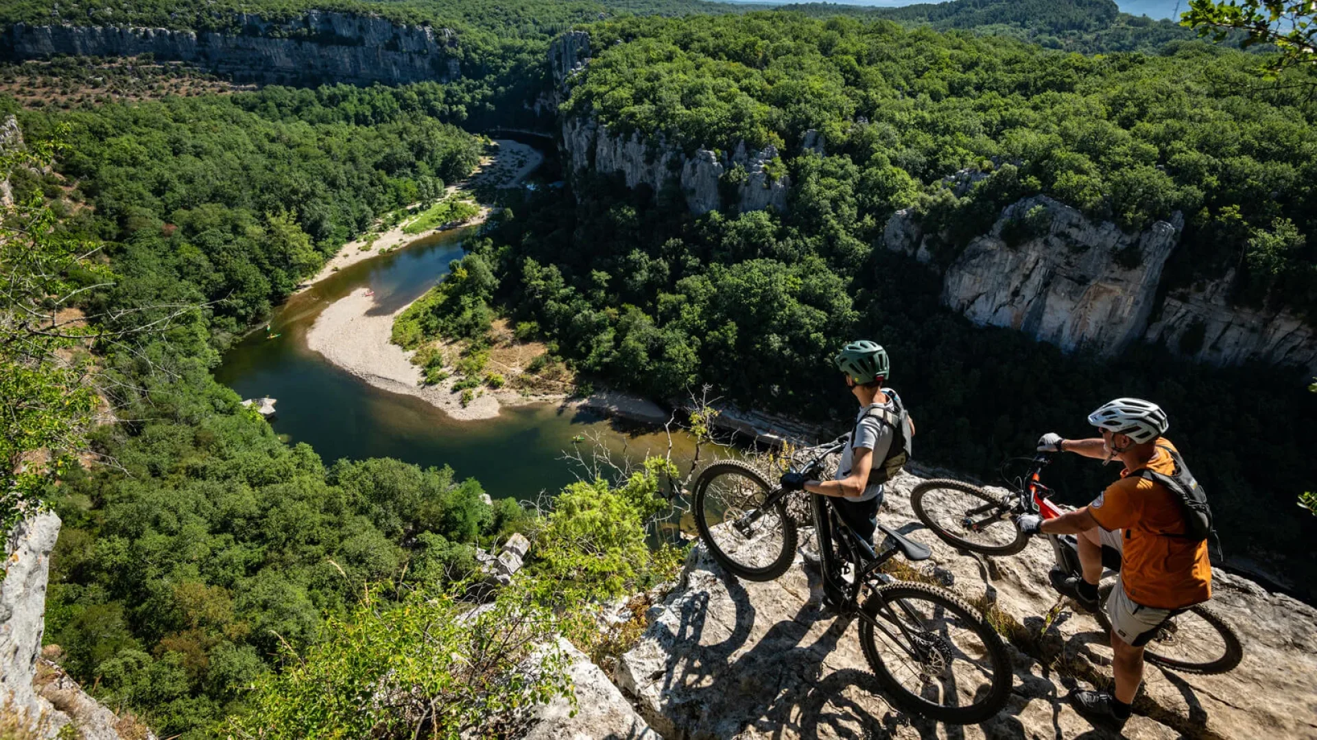 The Ardeche Great Mountain Bike Route - Two men on mountain bikes above the Chassezac gorges, in summer