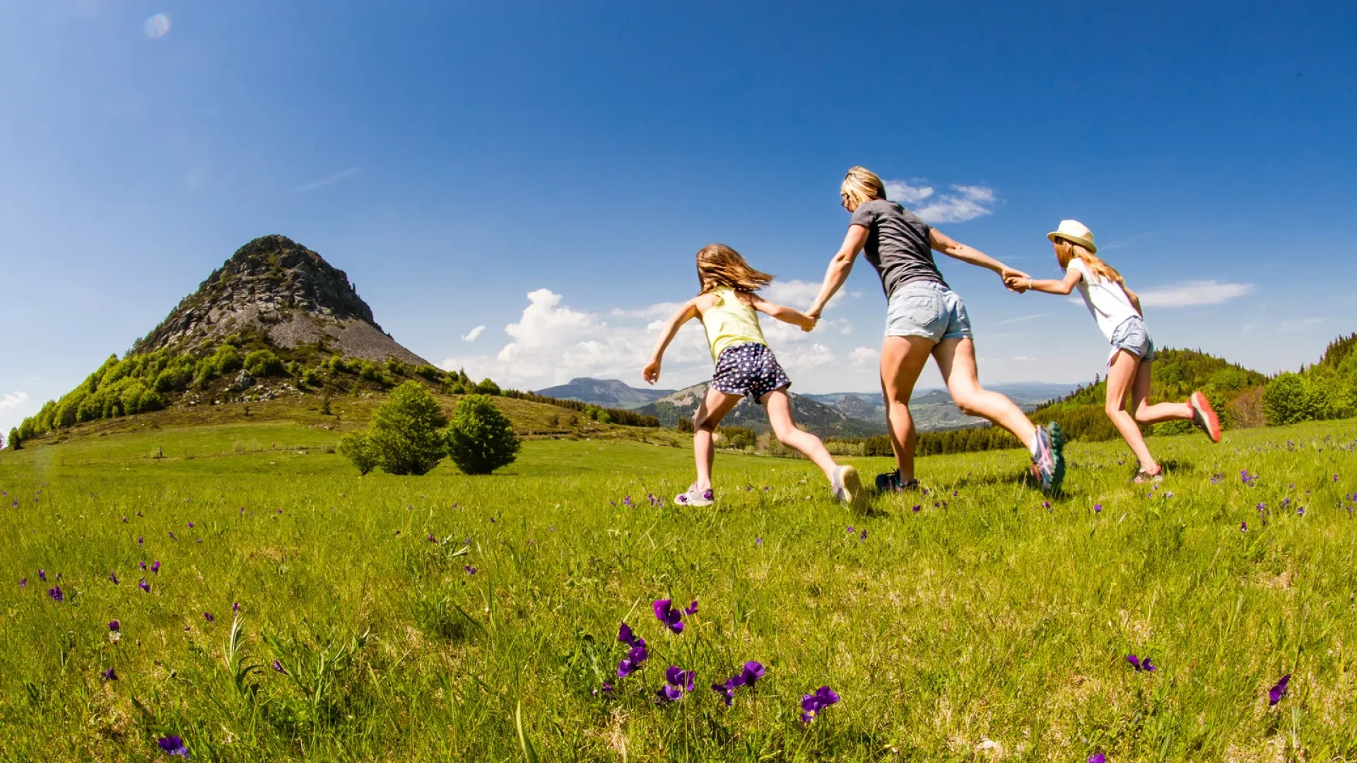 Family running towards Mont-Gerbier-de-Jonc in spring