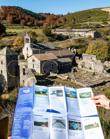 Two women looking at a map in front of Felice Varini's golden circles, a Watershed work, at Mazan Abbey, in autumn