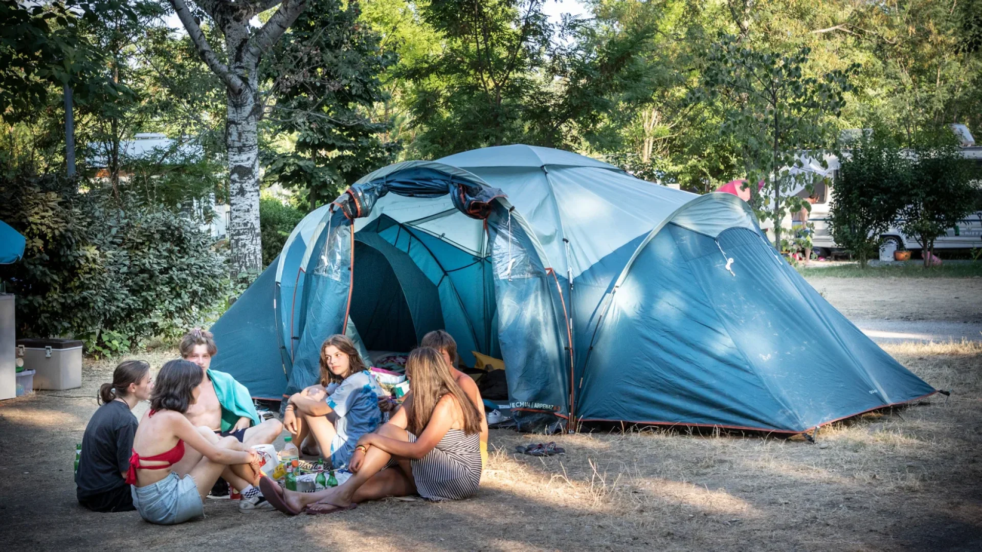 Group of friends in front of their tent, at the Huttopia campsite “Le moulin”