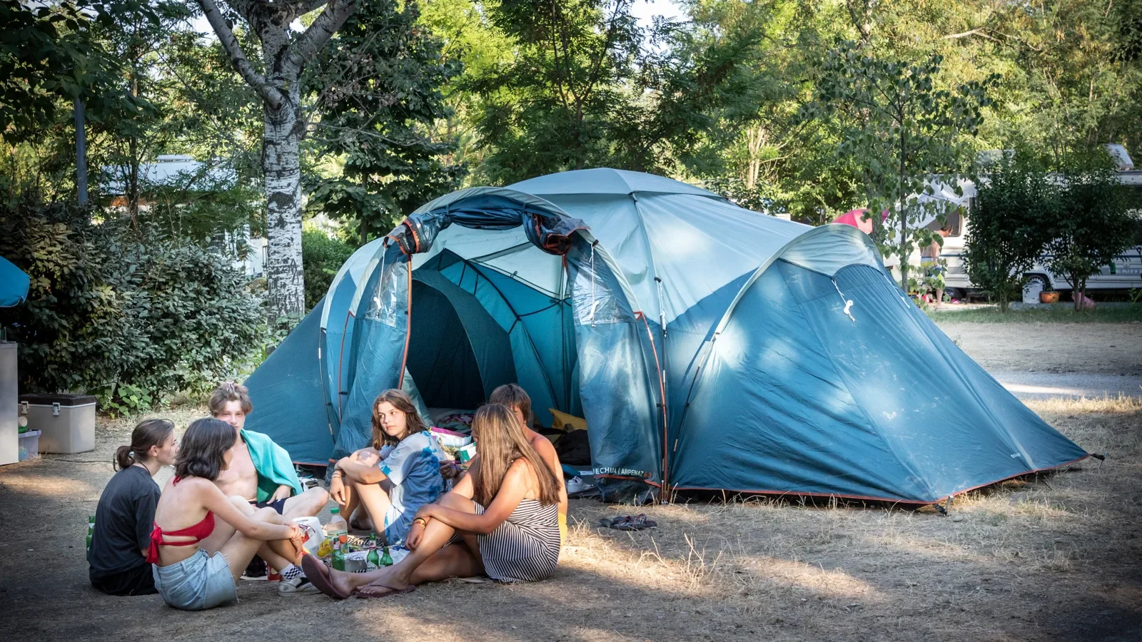 Group of friends in front of their tent, at the Huttopia campsite “Le moulin”