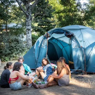 Group of friends in front of their tent, at the Huttopia campsite “Le moulin”