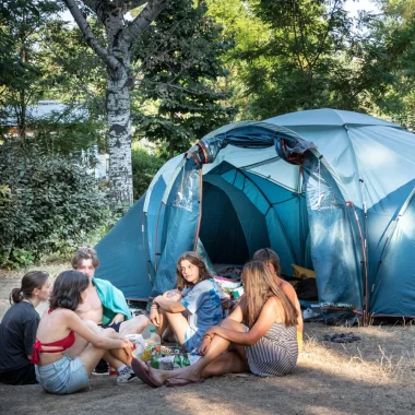 Group of friends in front of their tent, at the Huttopia campsite “Le moulin”