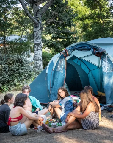 Group of friends in front of their tent, at the Huttopia campsite “Le moulin”