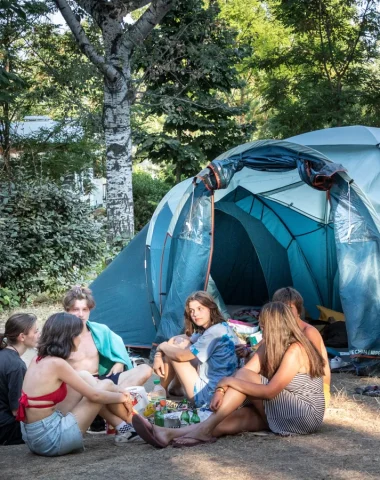Group of friends in front of their tent, at the Huttopia campsite “Le moulin”