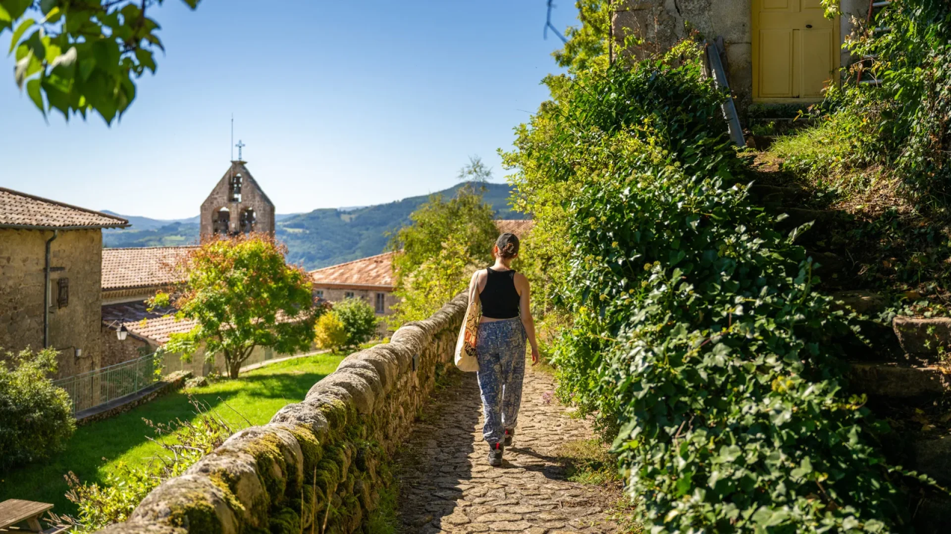 Woman in an alley of the village with outstanding character of Chalencon, in summer