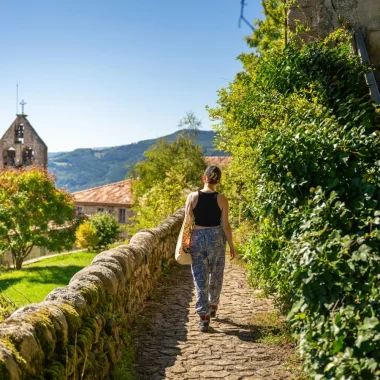 Woman in an alley of the village with outstanding character of Chalencon, in summer