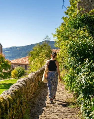 Woman in an alley of the village with outstanding character of Chalencon, in summer