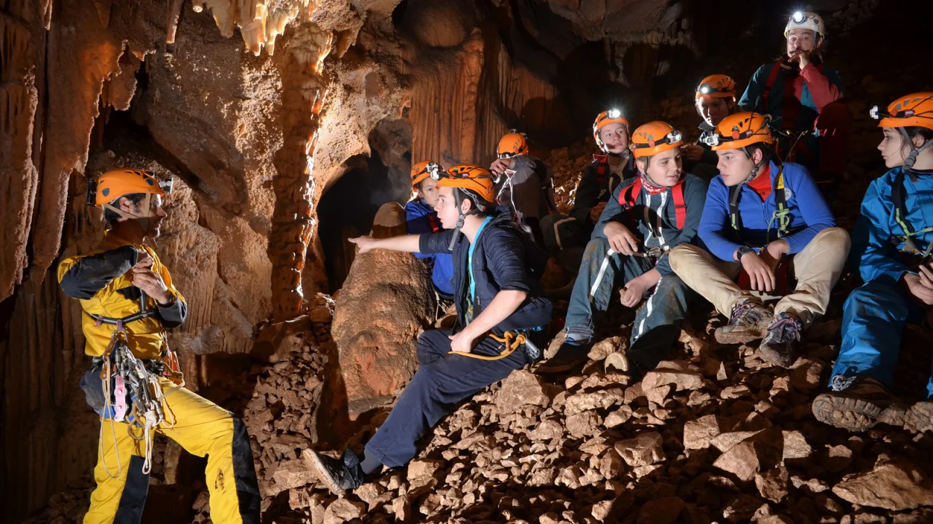 Group of teenagers practicing caving with a guide
