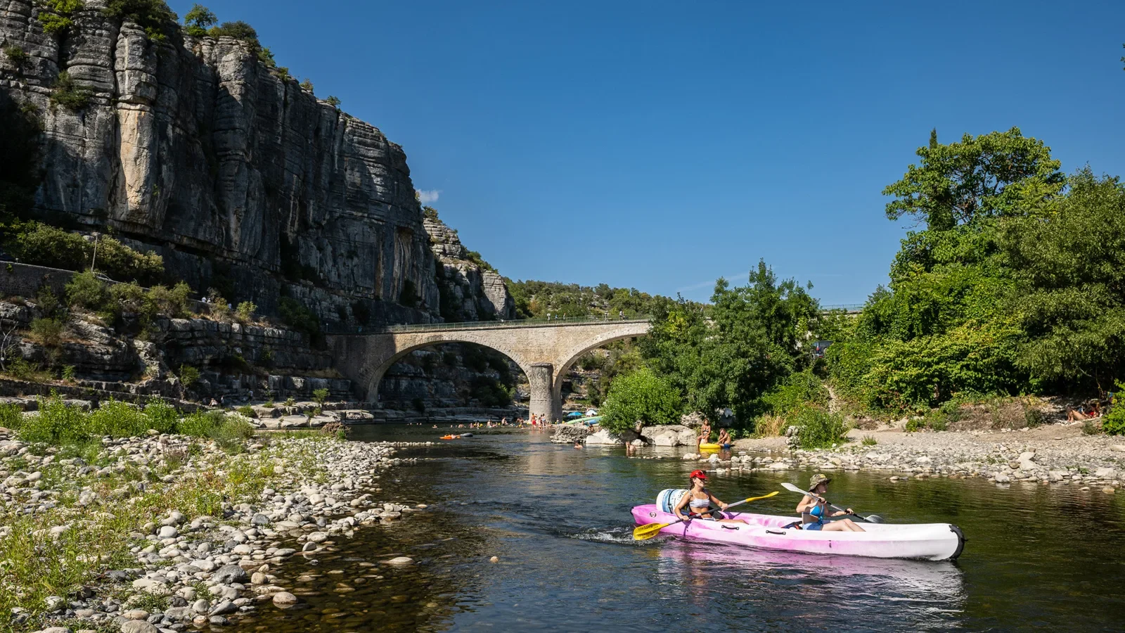 Women in a canoe near the village with outstanding character of Balazuc, in summer