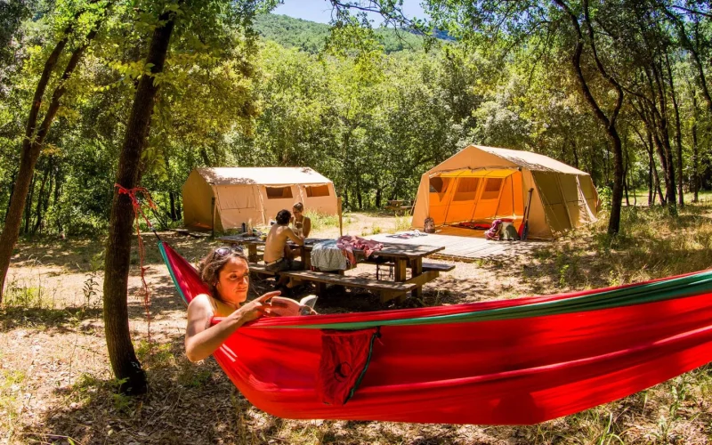 Woman relaxing in a hammock during a bivouac in the Ardèche Gorges, in summer