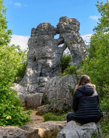 Woman observing the “bear and the lion” of the Bois de Païolive in spring