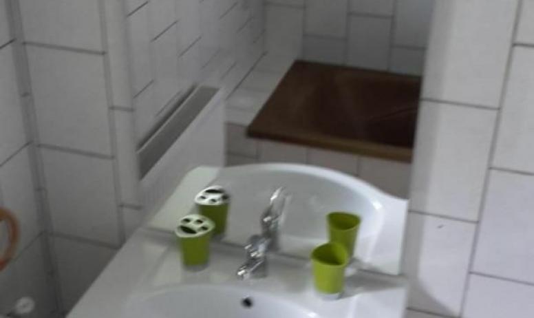 Gîtes de France - Salle de bains, lavabo et son meuble. Grand miroir