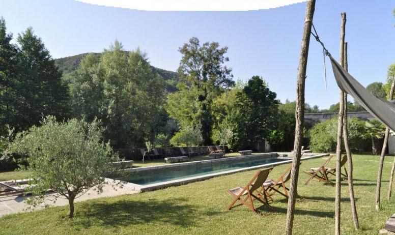 Au Château d'Uzer, près de la rivière, la piscine façon grand bassin de nage ourlé de pierre (18mx4,5m), ses plages et ses estrades.