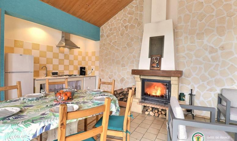 Gîtes de France - Pièce de vie avec coin cuisine, table repas, et cheminée