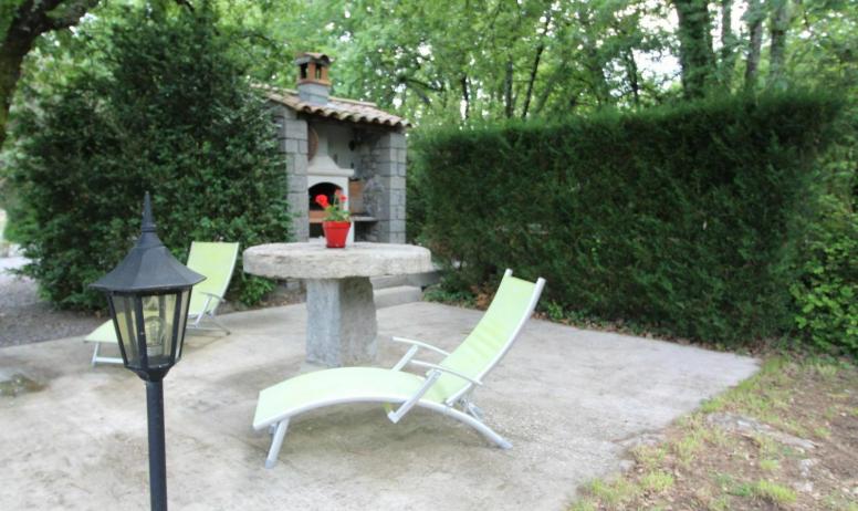 Gîtes de France - Barbecue et table en pierre pour apéros à l'ombre des chênes