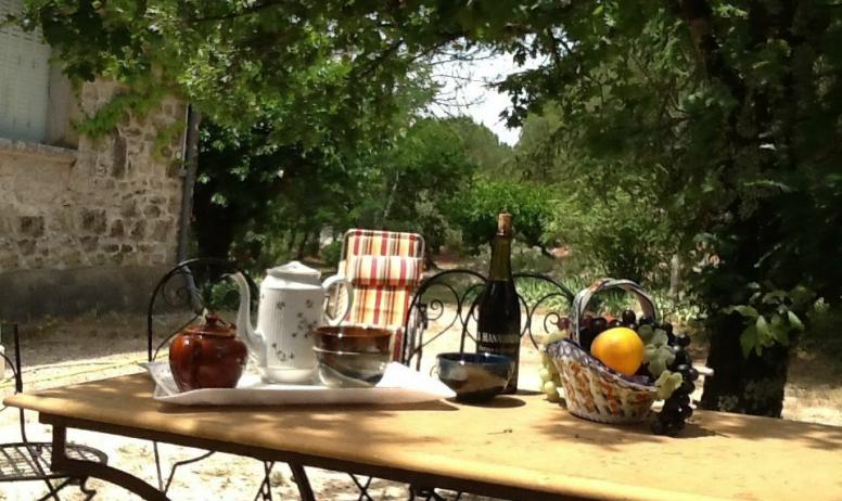 Gîtes de France - Petit déjeuner dans le jardin à l'arrière de la maison.