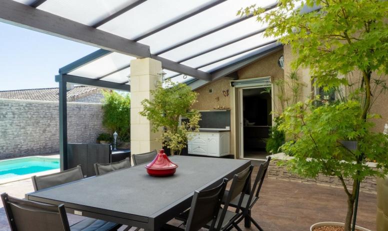 Gîtes de France - Sous la terrasse couverte, salon de jardin idéal pour repas barbecue